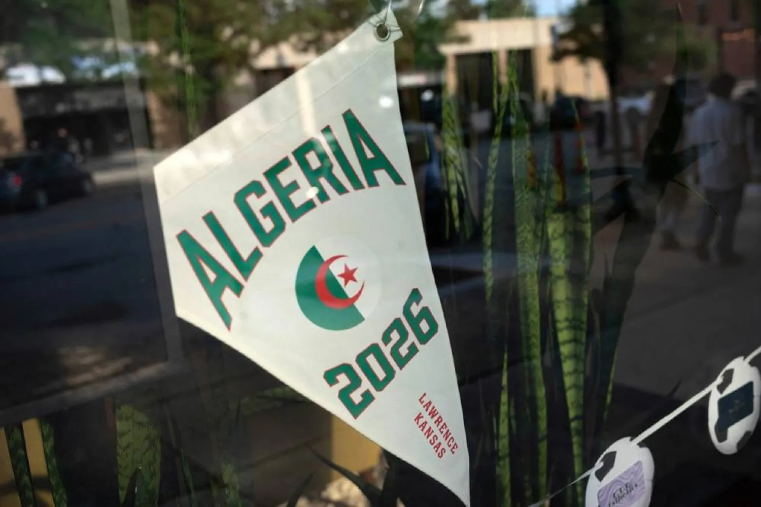 A pennant of Algeria, whose home base for the 2026 World Cup tournament is at the nearby University of Kansas, is displayed in a shop window before the game against Argentina, in Lawrence, Kansas, US, June 16, 2026. (Reuters) 