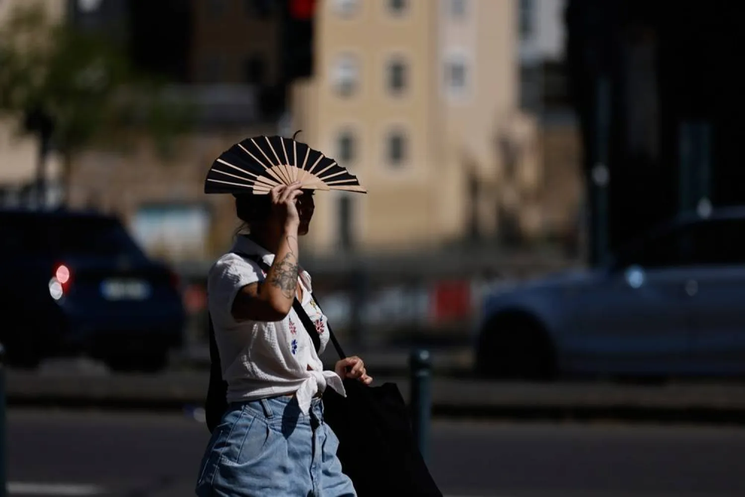  A woman shields herself from the sun with a fan in Rennes, western France, Monday, June 22, 2026. (AP) 