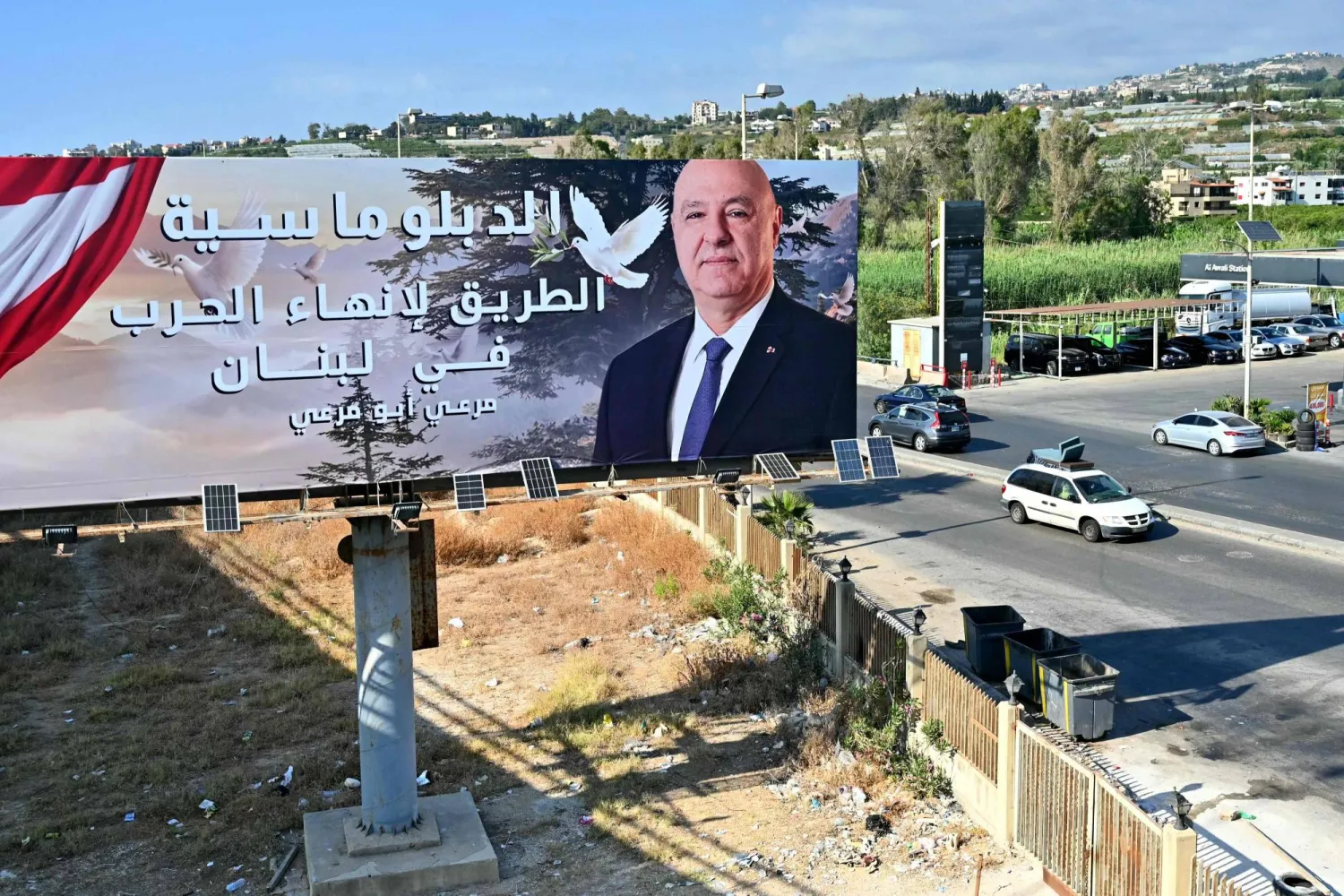 لوحة للرئيس اللبناني جوزيف عون كُتب عليها «الدبلوماسية هي الطريق لإنهاء الحرب في لبنان» على الطريق الساحلي بمدينة صيدا (أ.ف.ب)
