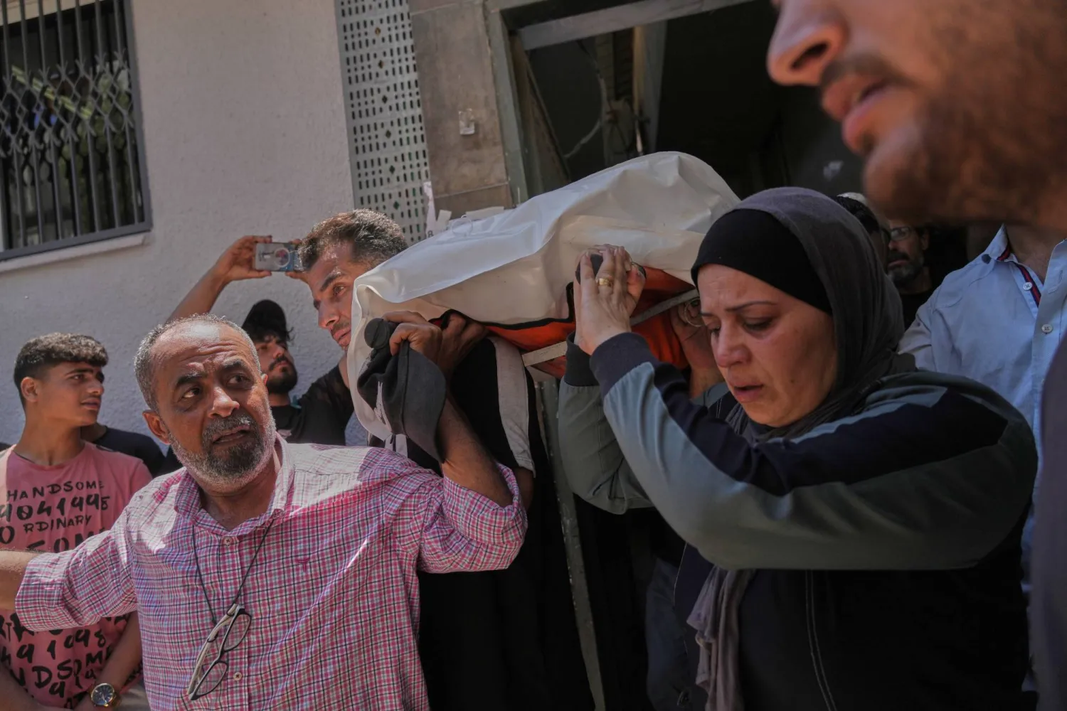 Mourners carry the body of Palestinian Raghad Hassan Ashour, 16, during her funeral at Al-Shifa Hospital after she was killed in an Israeli airstrike, in Gaza City, Monday June 22, 2026. (AP Photo/Jehad Alshrafi)