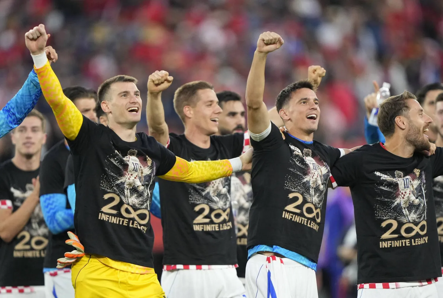 يحتفل لاعبو كرواتيا بقميص يحمل الرقم 200 عدد مباريات مودريتش (رويترز)
