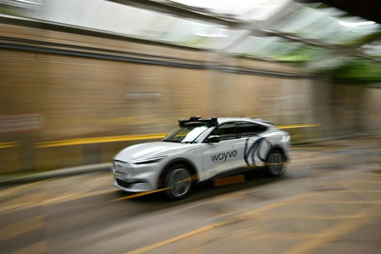 A car from British autonomous driving technology company Wayve Technologies Ltd is pictured driving around the street, on the sidelines of London Tech Week in London on June 8, 2026. (AFP) 