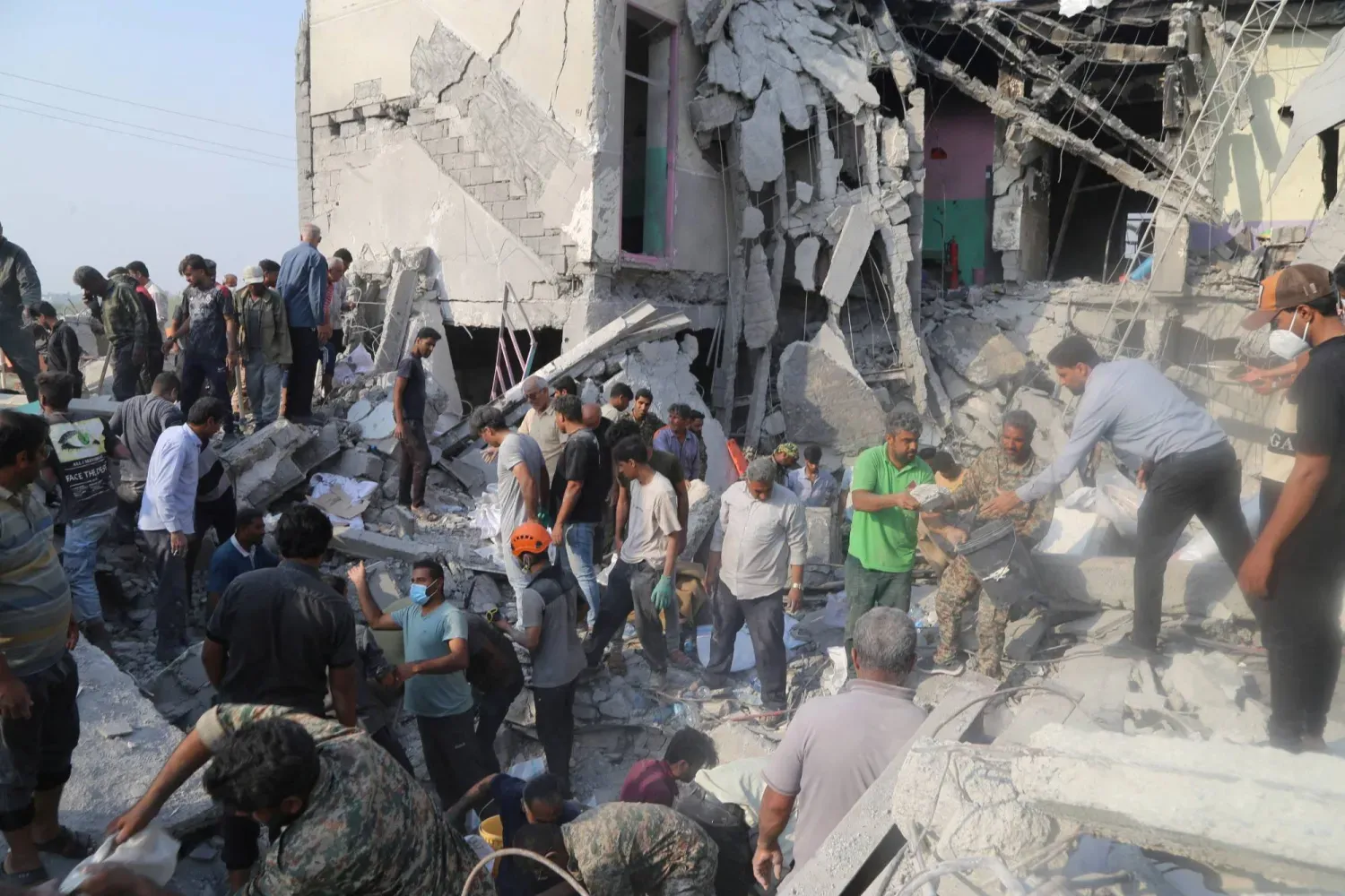 İran'ın Minab kentindeki bir okula düzenlenen saldırının olay yerinde bulunan sakinler ve kurtarma ekipleri (Reuters)