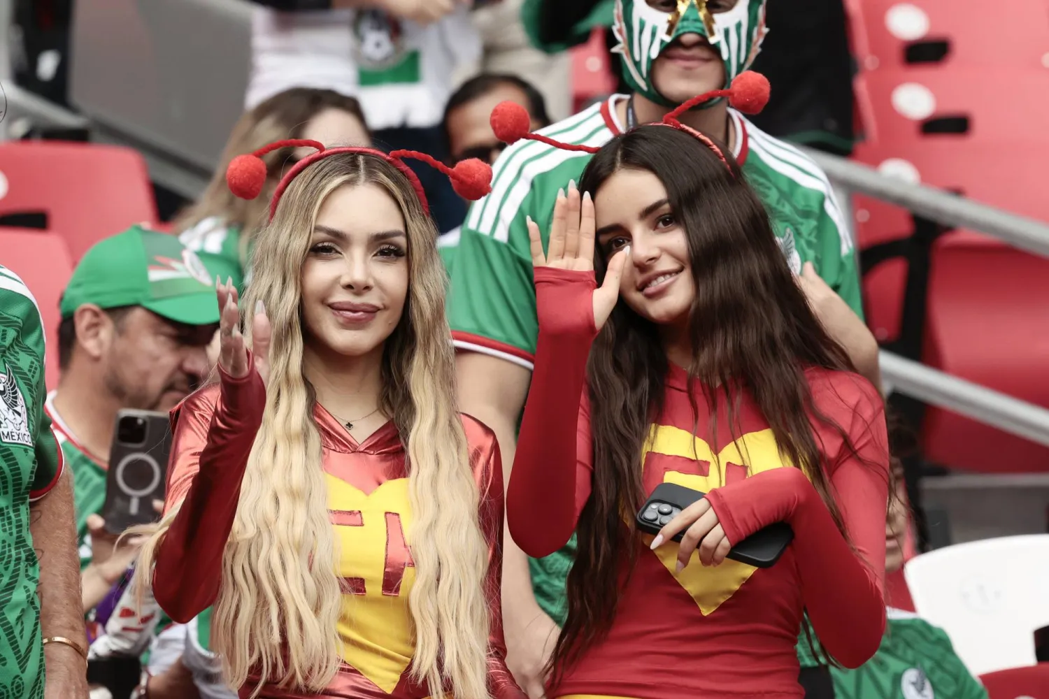 تلوح مشجعة بيدها لعدسة الكاميرا في ملعب المباراة (إ.ب.أ) 