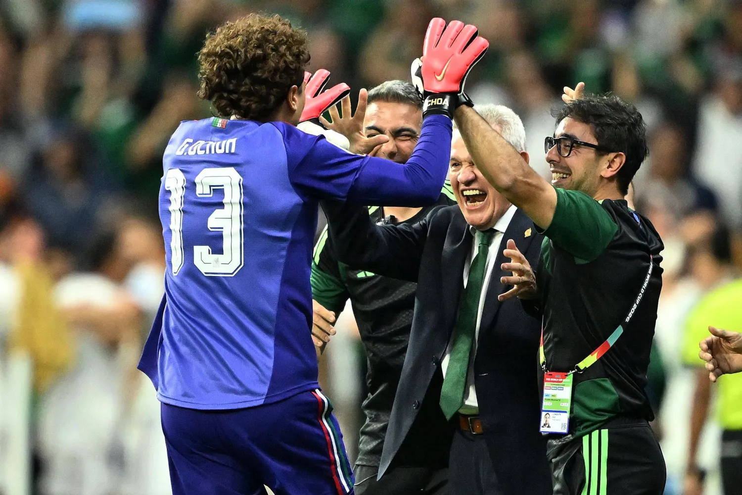 خافيير أغيري المدير الفني للمنتخب المكسيكي وتحية للحارس المخضرم أوتشوا (أ.ف.ب) 