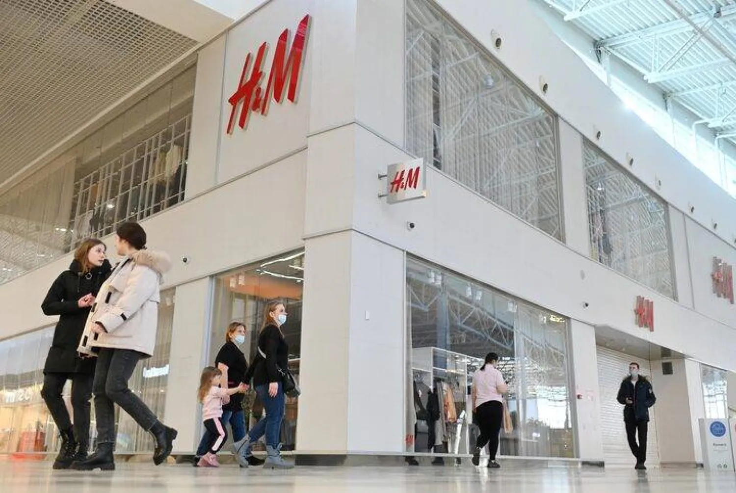People walk past a closed H&M clothing store in Omsk, Russia, March 3, 2022. REUTERS/Alexey Malgavko