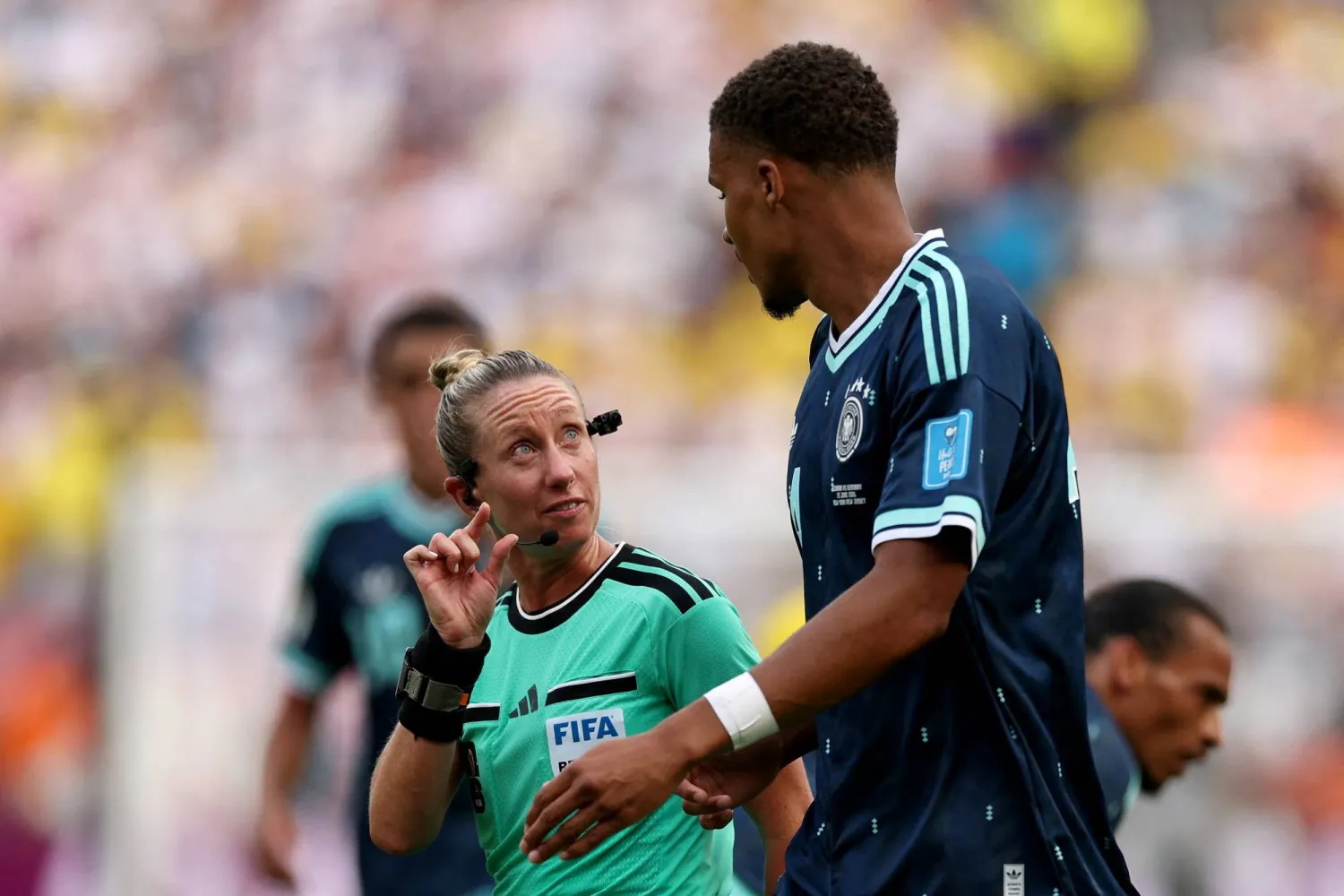 الحكمة توري بينسو تتحدث مع مالك تياو لاعب ألمانيا (أ.ف.ب)
