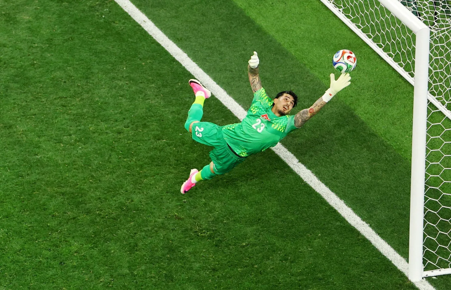 الحارس التركي أوغورجان شاكير يتصدى لكرة من اللاعب الأميركي كريستيان بوليسيتش (رويترز) 