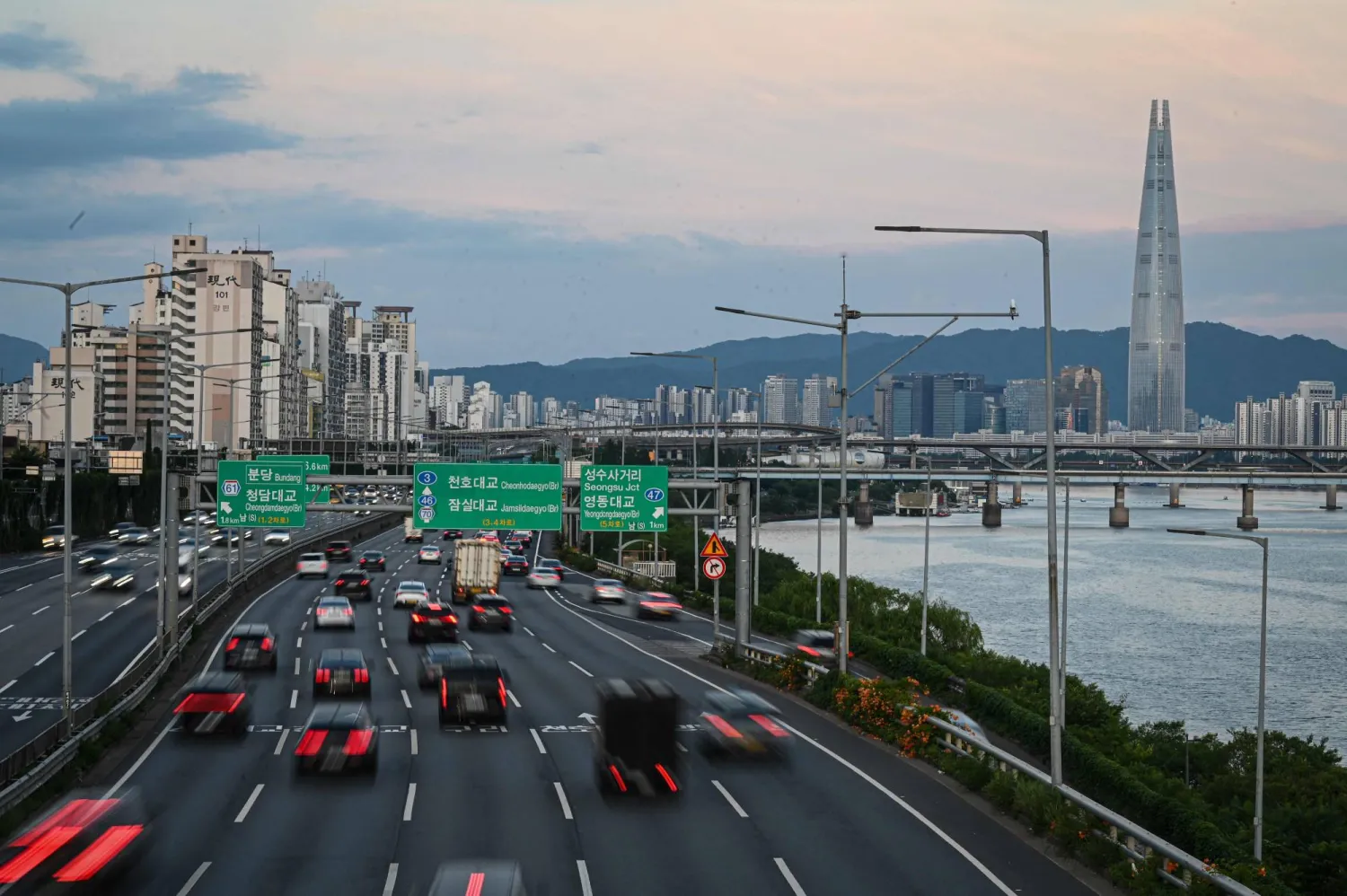 Motorists commute on a road along the Hangang River in Seoul on June 24, 2026. (Photo by Jade GAO / AFP)