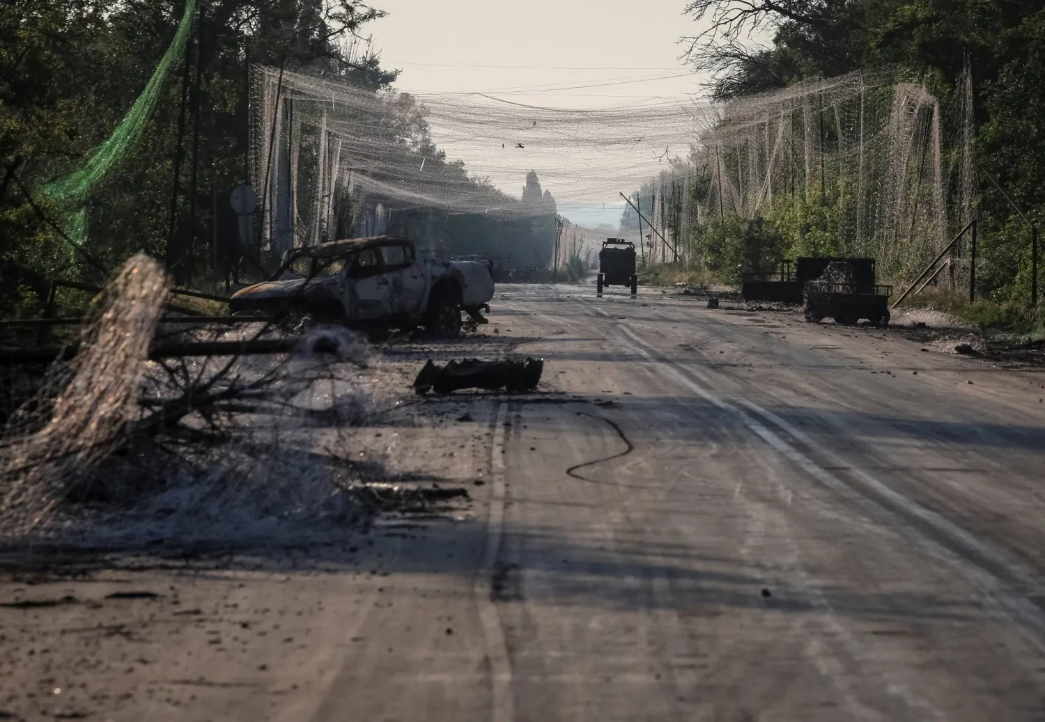 Destroyed military vehicles and anti drone nets at a road between frontline towns of Druzhkivka and Kostiantynivka, amid Russia's attack on Ukraine, in Donetsk region, Ukraine June 24, 2026. REUTERS/Anatolii Stepanov