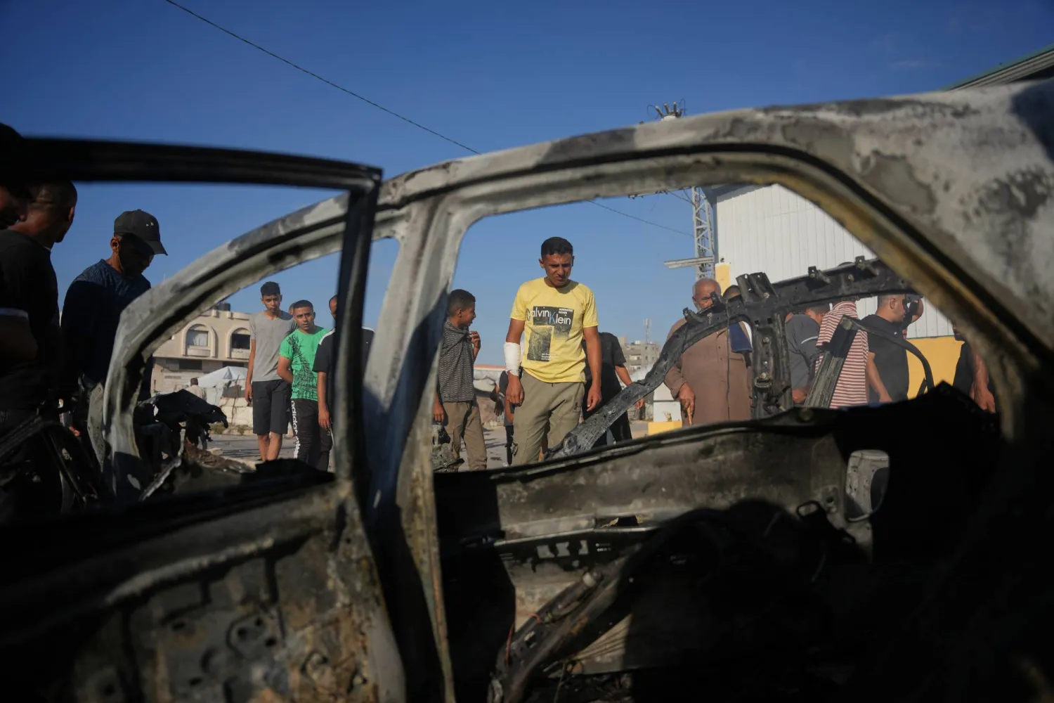 فلسطيني يتفحص سيارة تعرضت لغارة إسرائيلية في مخيم المغازي وسط قطاع غزة (أ.ب)