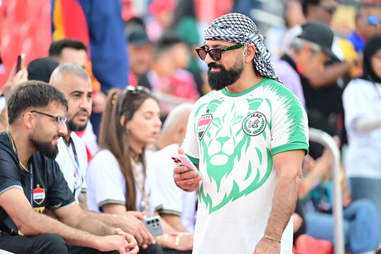 مشجعون عراقيون يلتقطون الصور قبل انطلاق المواجهة (إ.ب.أ)