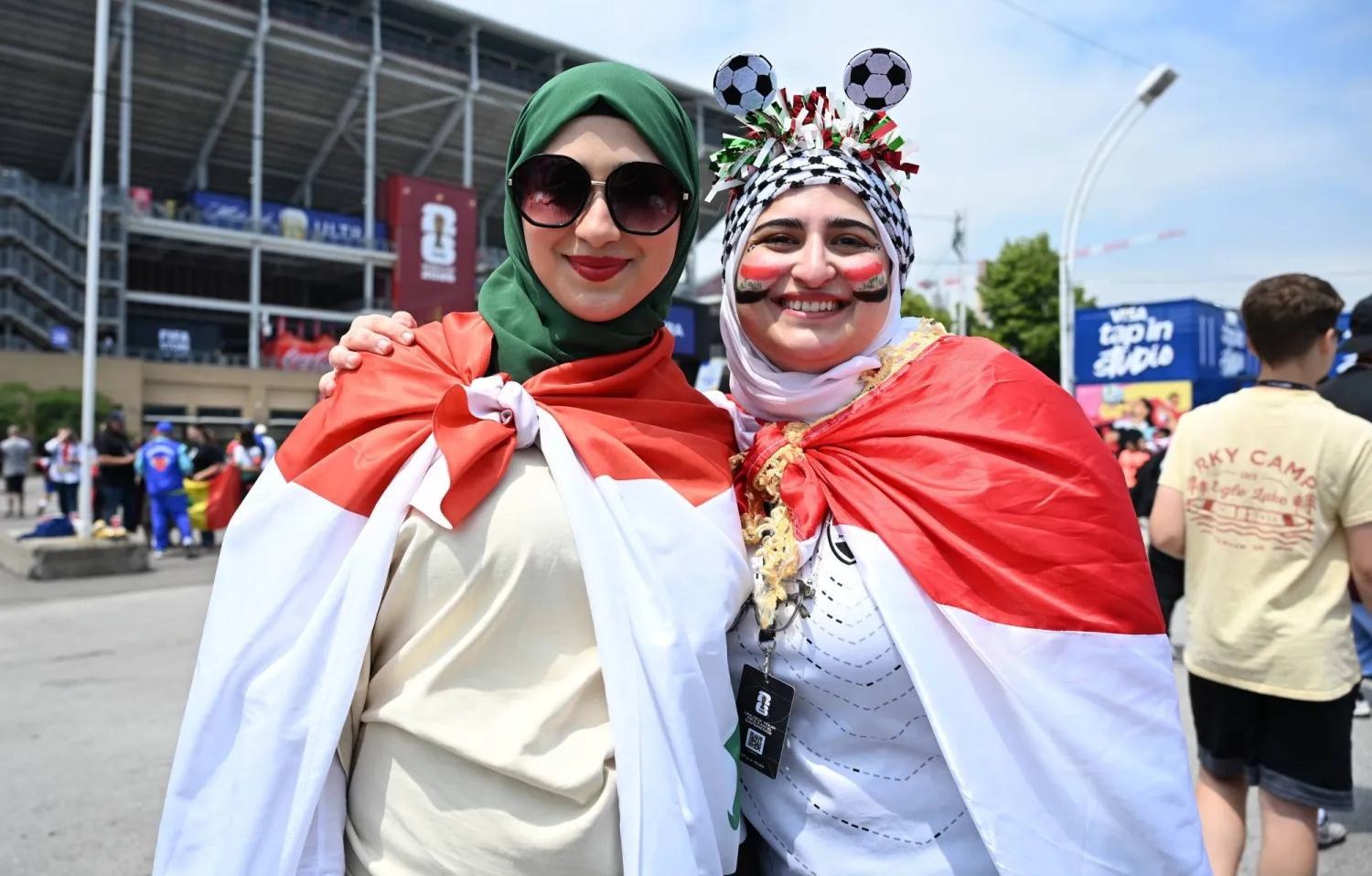 مشجعون عراقيون يلتقطون الصور أثناء توجههم إلى الملعب (إ.ب.أ)