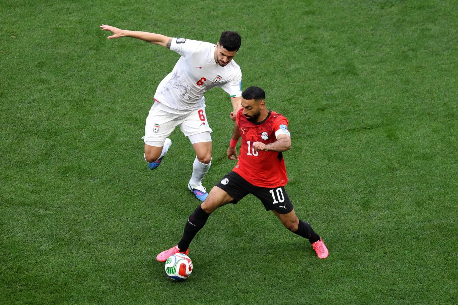 يسيطر محمد صلاح على الكرة وسط مطاردة إيرانية (أ.ف.ب)