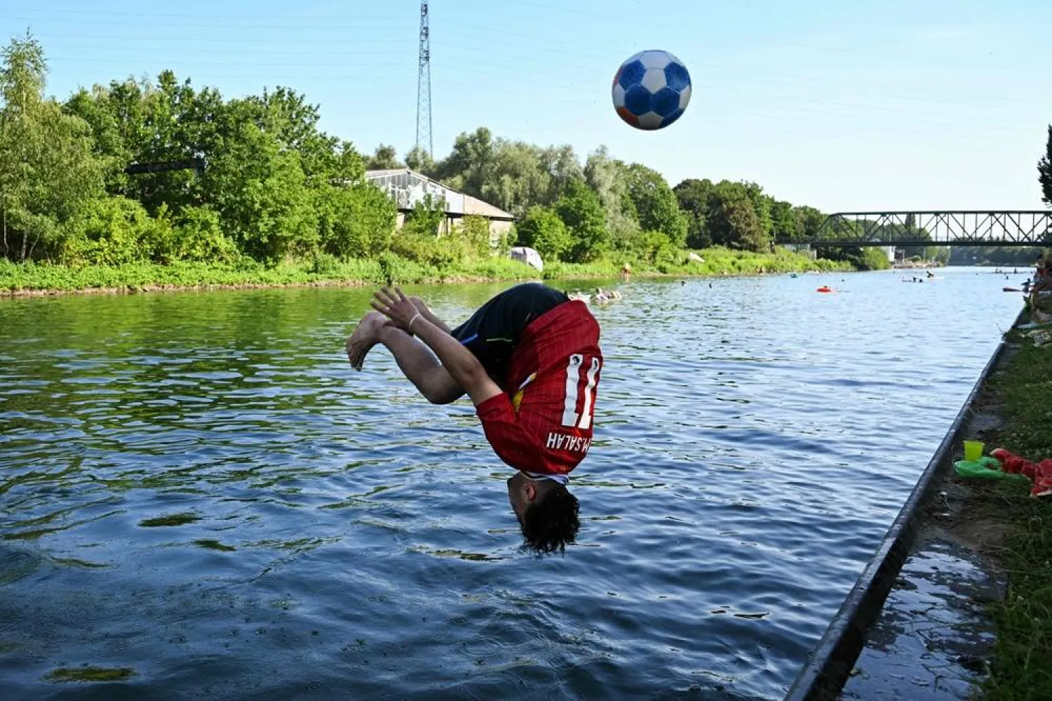 A boy jumps into the Dortmund-Ems Canal in Dortmund, western Germany on June 26, 2026 during a heatwave in Europe. (AFP)