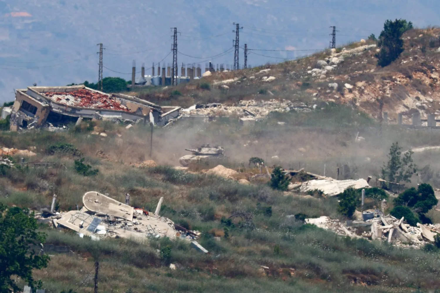 An Israeli tank maneuvers amid destroyed structures in Lebanon, after Israel and Lebanon signed a framework agreement following US-mediated talks, as seen from northern Israel, June 27, 2026. REUTERS/Amir Cohen