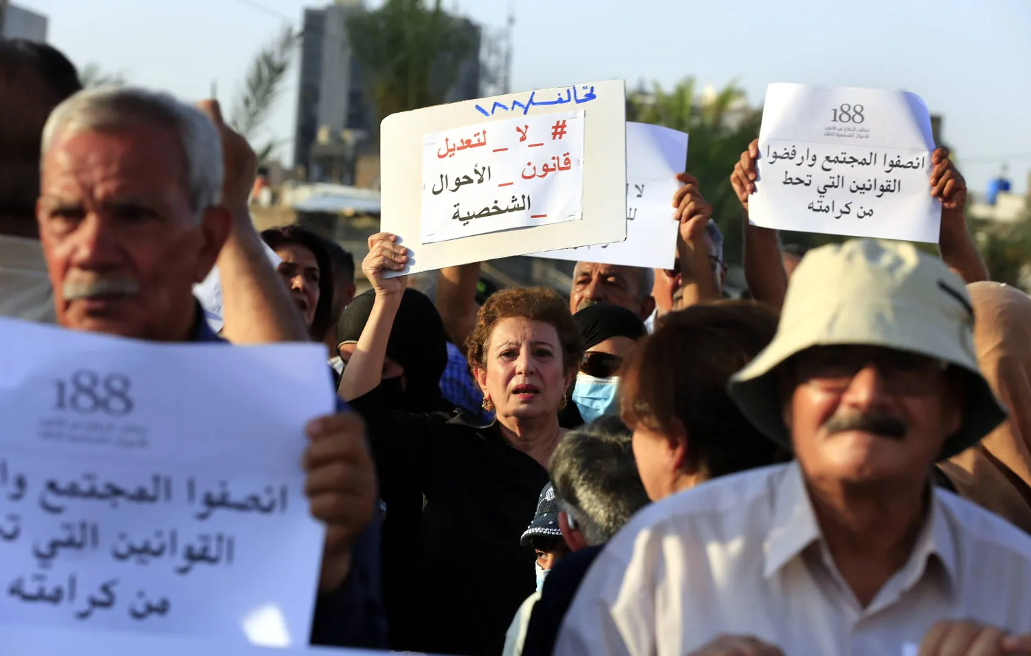 عراقية تحمل لافتة «لا لتعديل قانون الأحوال الشخصية» خلال احتجاج وسط بغداد في أغسطس 2024 (إ.ب.أ)