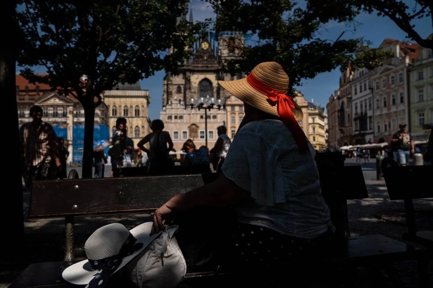 A woman sits in the shade during a hot, sunny day at Old Town Square in Prague, Czech Republic, 27 June 2026. (EPA)