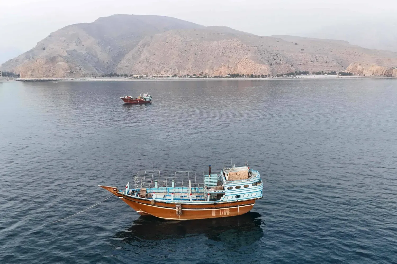 Umman Sultanlığı'nın kuzeyindeki Musandam Yarımadası açıklarında, Hürmüz Boğazı yakınlarında demirlemiş teknelerin havadan çekilmiş bir fotoğrafı, 27 Haziran 2026 (AFP)
