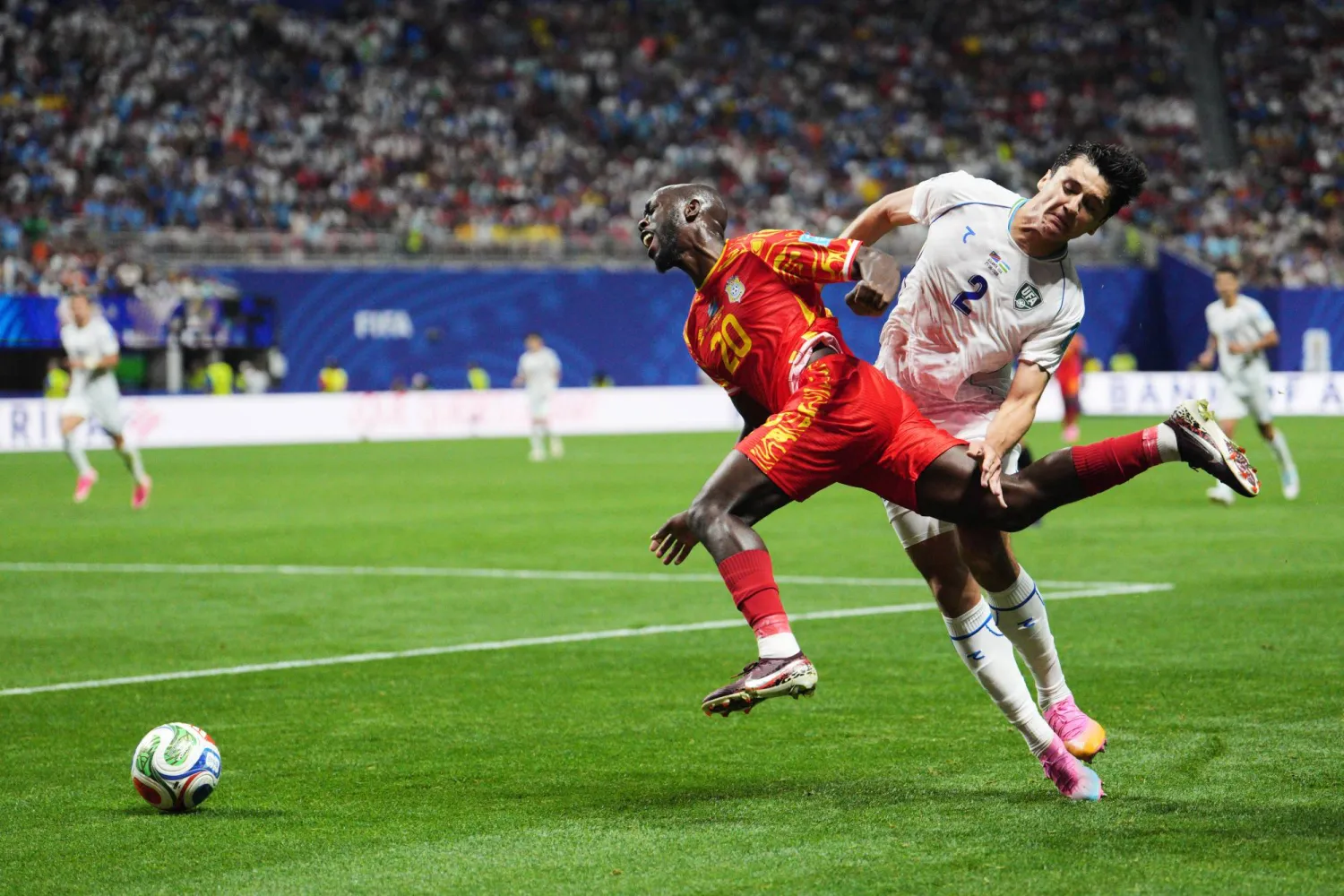 لاعب الكونغو  يوان ويسا يتعرض لعرقلة من قبل لاعب منتخب أوزبكستان عبد القادر خوسانوف (أ.ب)
