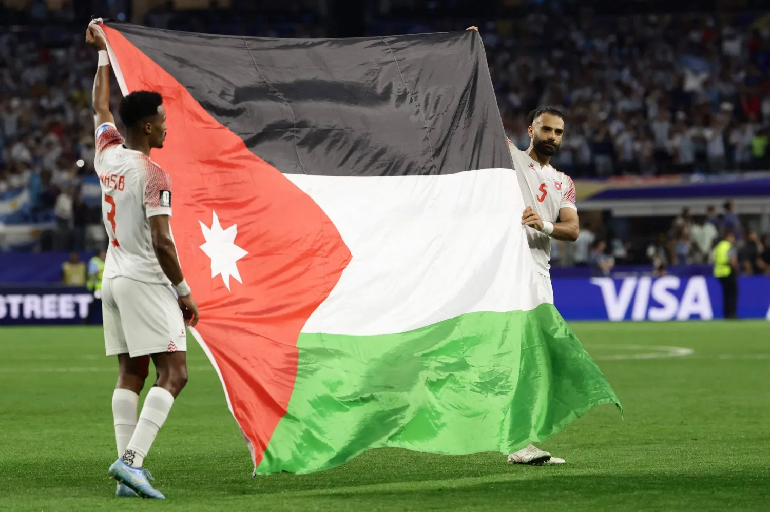 عبد الله نصيب ويزن العرب يحملان علم بلادهما بعد اللقاء (أ.ف.ب) 
