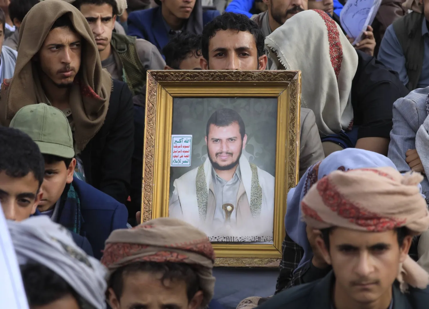 عناصر حوثيون يرفعون صورة زعيمهم خلال حشد في صنعاء (إ.ب.أ)