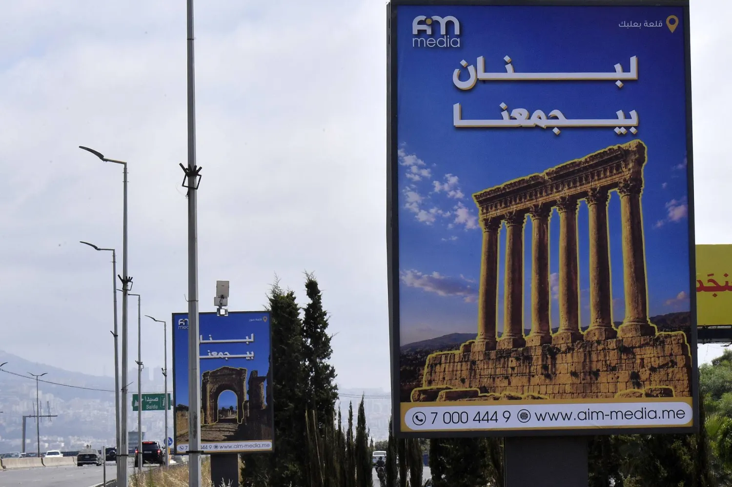 لوحات إعلانية تحمل شعار «لبنان يجمعنا» مثبتة على طريق مطار رفيق الحريري الدولي في بيروت (إ.ب.أ)