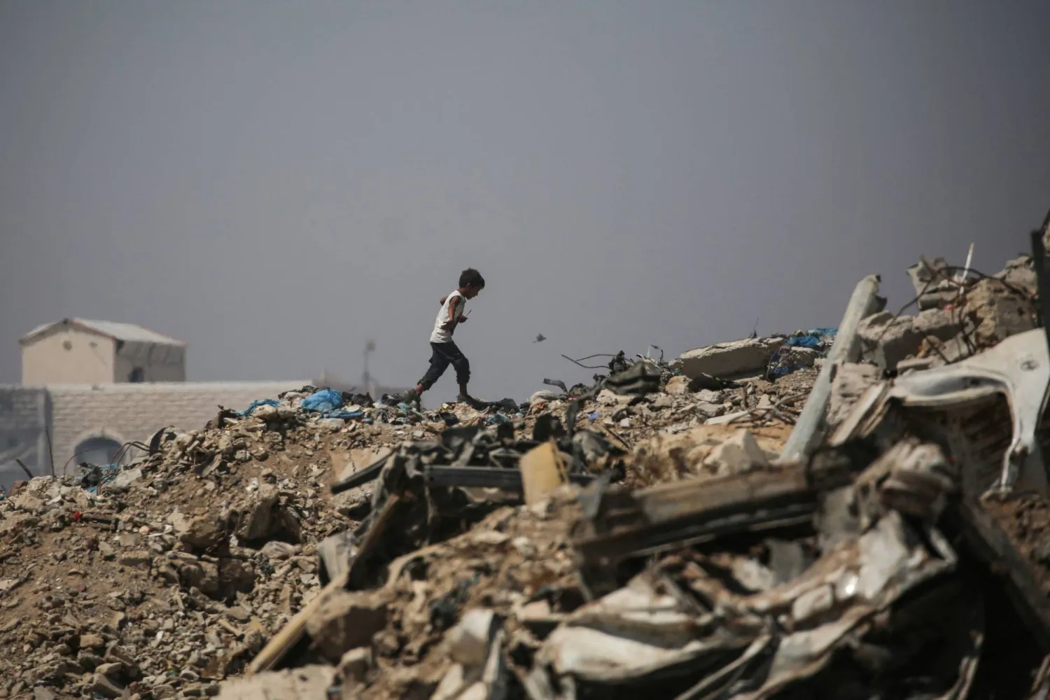 A Palestinian boy makes his way across rubble near a displacement camp in Nuseirat, in the central Gaza Strip, on June 28, 2026. (Photo by Eyad Baba / AFP)
