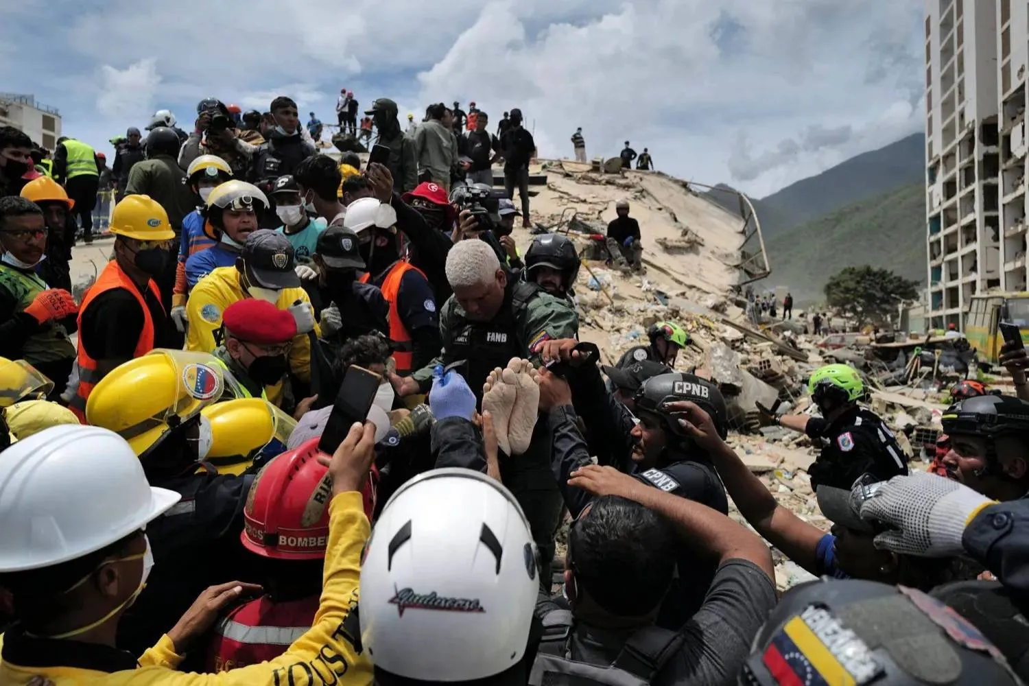 Relief workers carry a survivor rescued from a building that collapsed in the earthquakes that struck La Guaira, Venezuela. (AFP) 