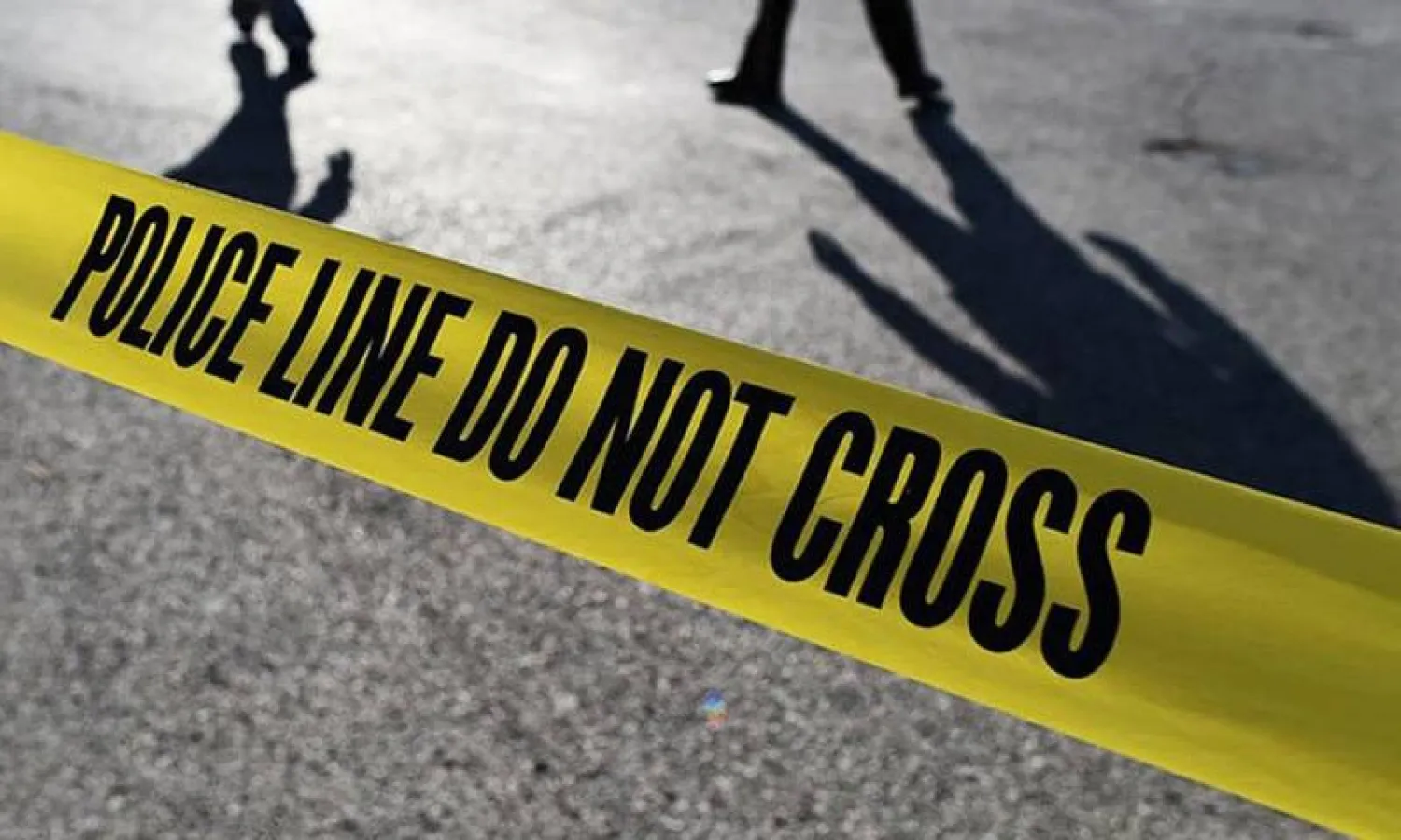 Police officials stand behind crime scene tape. — AFP/File

