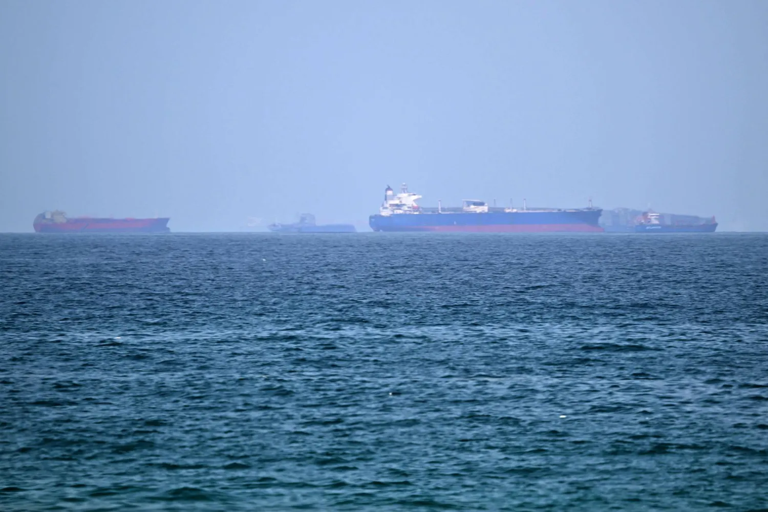 Cargo ships are pictured off the coast of the Khor Fakkan Container Terminal, the only natural deep-sea port in the region and one of the major container ports in Sharjah Emirate, along the Gulf of Oman on June 28, 2026. (Photo by AFP)