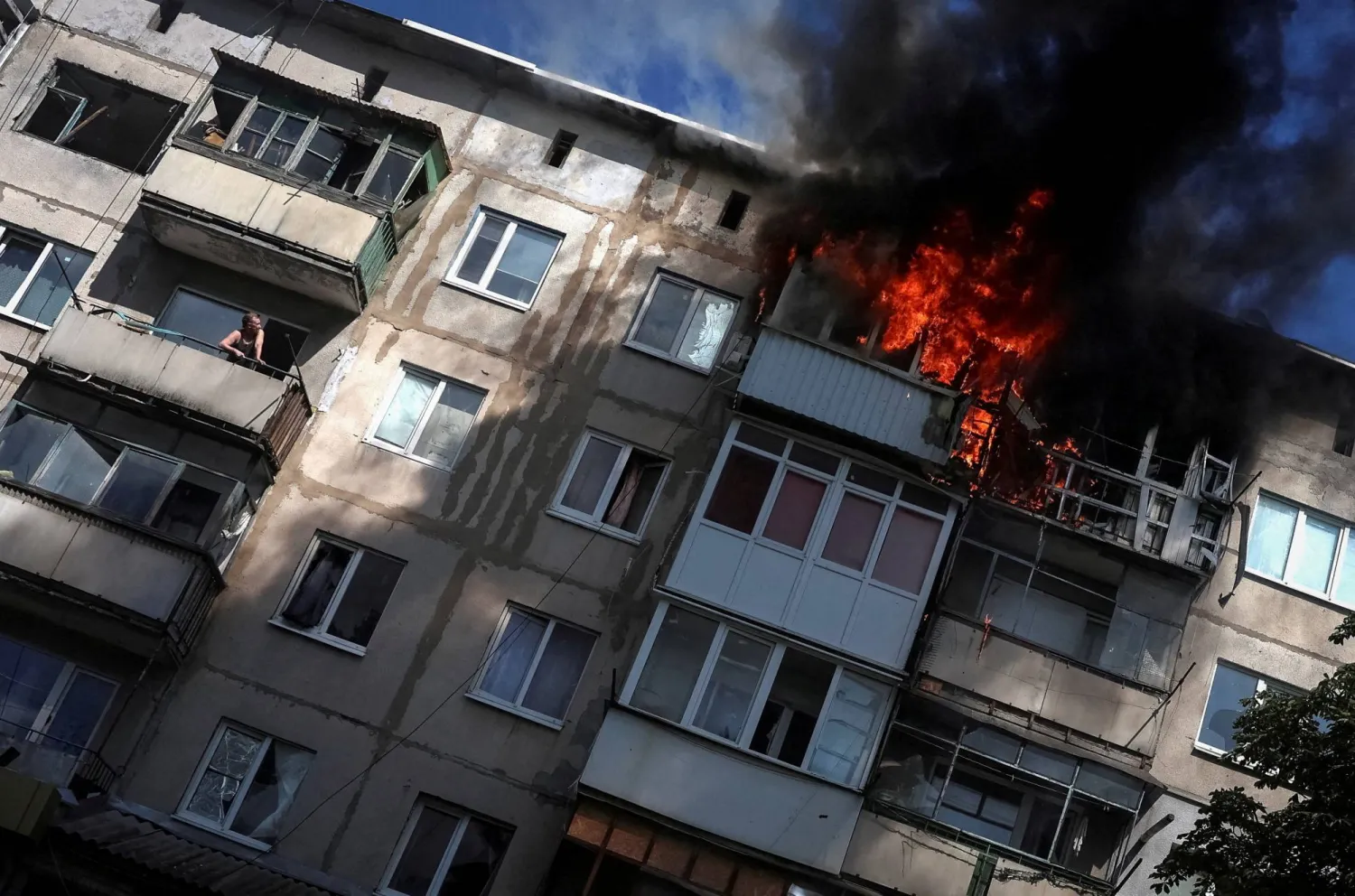 FILE PHOTO: A resident watches from his balcony as another flat burns after being hit by a Russian drone, amid Russia's attack on Ukraine, in the frontline town of Druzhkivka, in Donetsk region, Ukraine, June 22, 2026. REUTERS/Anatolii Stepanov