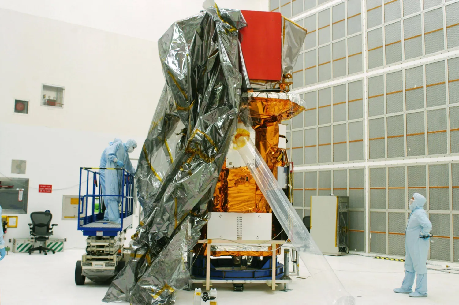 This handout photo released by NASA on July 31, 2004, shows the Swift spacecraft being unwrapped in Hangar AE at Cape Canaveral Air Force Station at Kennedy Space Center, Florida. (Photo by Handout / NASA / AFP) 