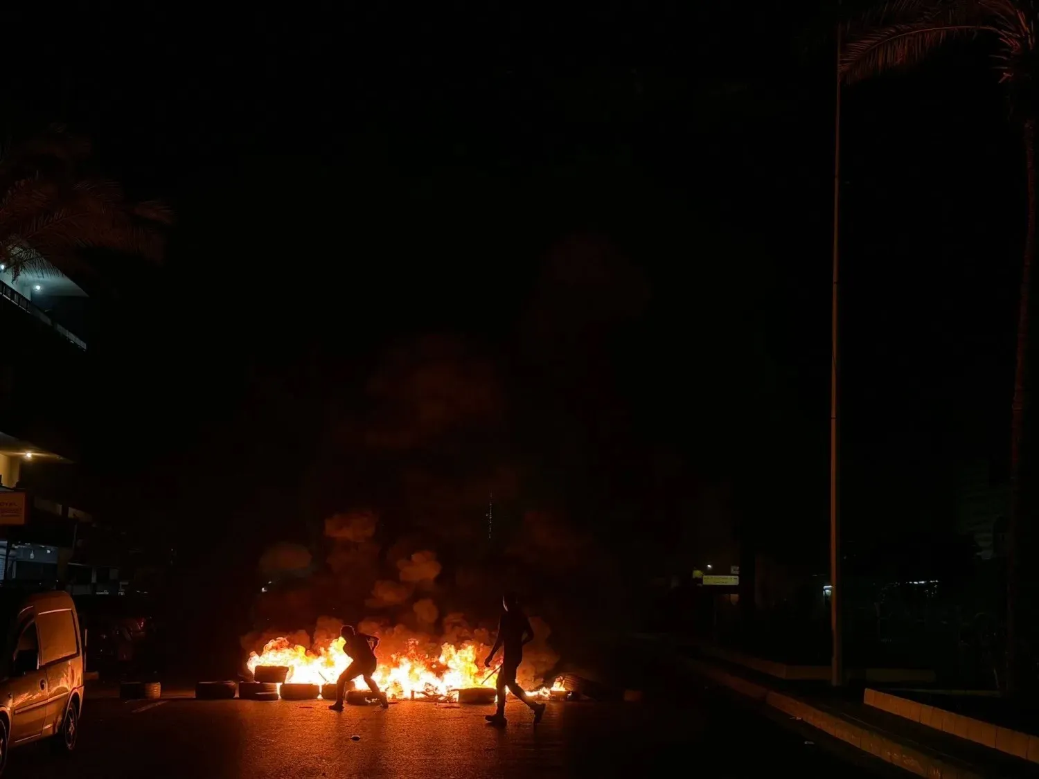 Hezbollah supporters block the old airport road in Beirut’s southern suburbs with burning tires on Saturday to protest the 2026 trilateral agreement signed by the United States, Israel, and Lebanon (AFP)