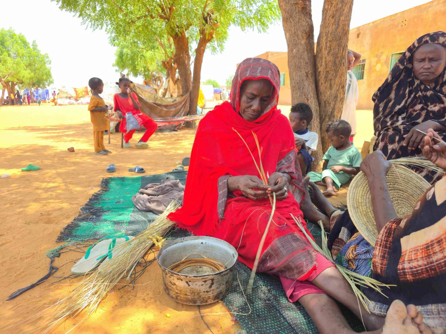 Sudanese women make a wicker bowl at the al-Rahmaniyah camp for displaced people, near the city of El-Obeid in the South Kordofan region, on June 29, 2026. (Photo by AFP)