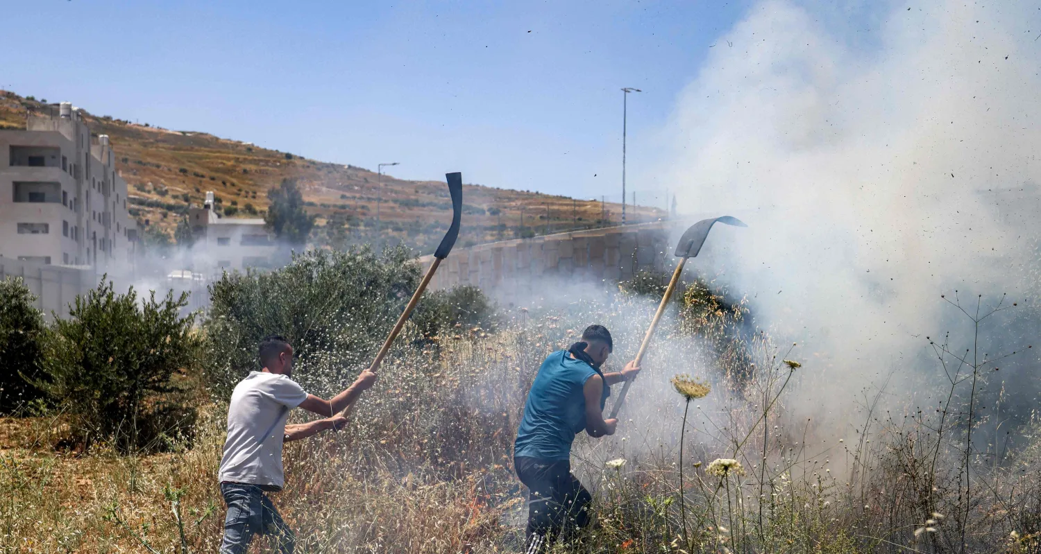 Men attempt to extinguish a fire in a field in the Palestinian town of Huwara in the occupied West Bank on June 6, 2026, after a reported arson attack by Israeli settlers according to local officials. (Photo by JAAFAR ASHTIYEH / AFP)