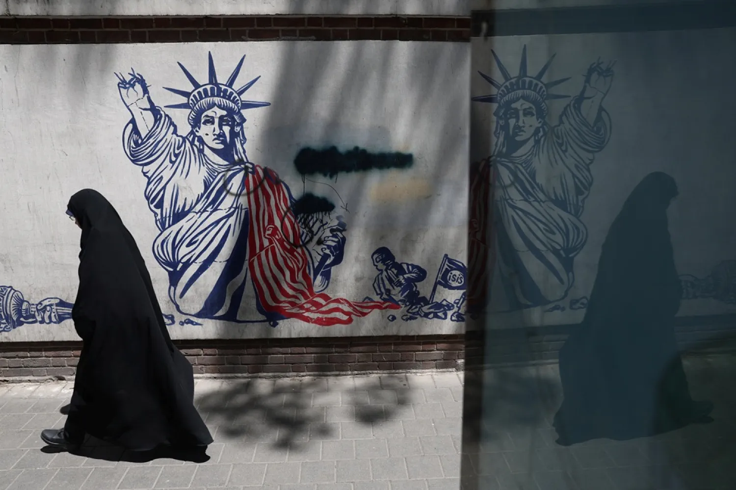 A woman walks past an anti-US mural on a street in Tehran, Iran, June 1, 2026. Majid Asgaripour/WANA (West Asia News Agency) via Reuters 
