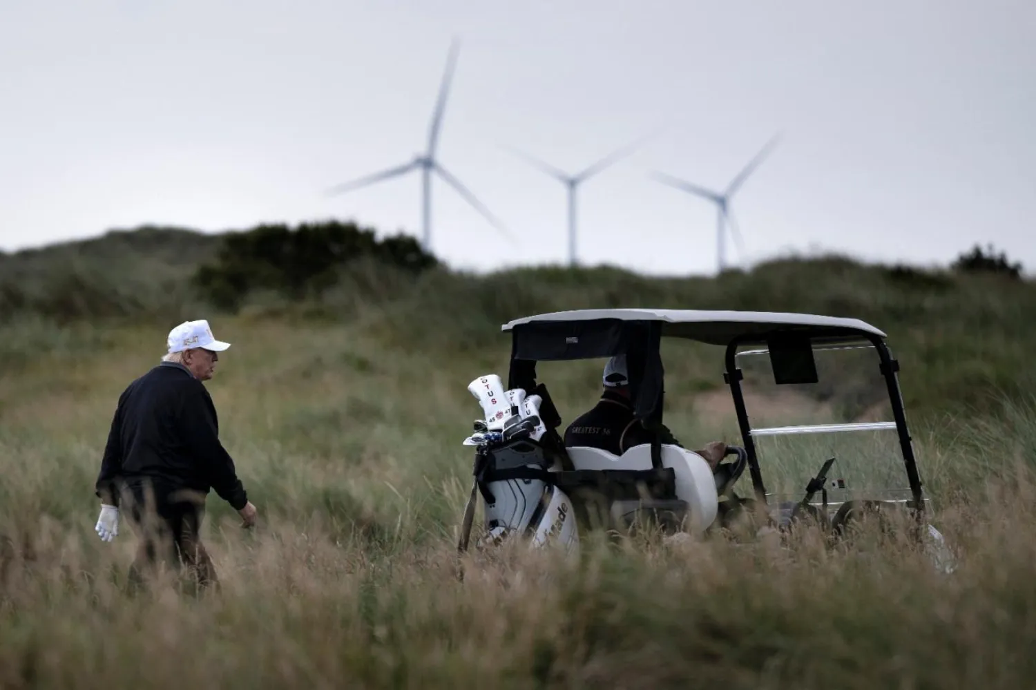 İskoçya'nın Aberdeenshire kentindeki golf sahasında görülen Donald Trump'ın rüzgar santrallerini sert bir şekilde eleştirdiği biliniyor (AFP)