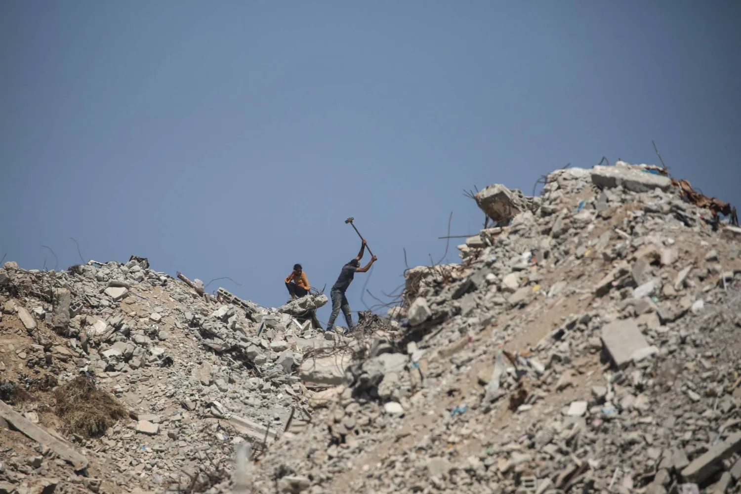  Palestinian man uses a sledgehammer on the rubble of destroyed buildings near a displacement camp in Nuseirat, in the central Gaza Strip, on June 28, 2026. (AFP)