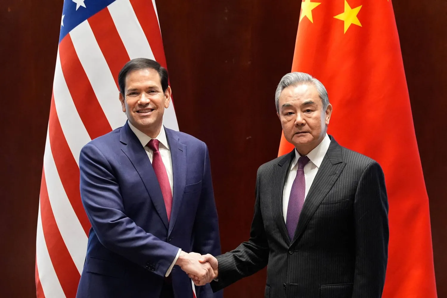  US Secretary of State Marco Rubio (L) shakes hands with China's Foreign Minister Wang Yi in Munich, on February 12, 2026. (AFP/Getty Images)
