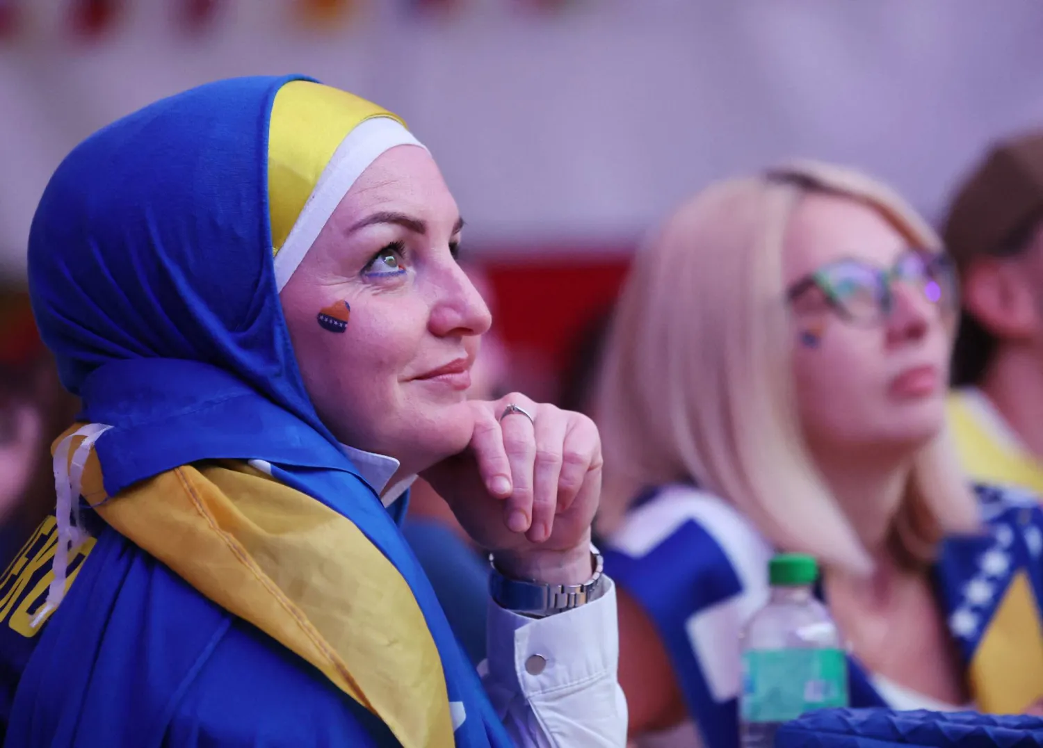 مشجعة بوسنية تتابع المباراة في تجمُّع بالعاصمة سراييفو (رويترز) 