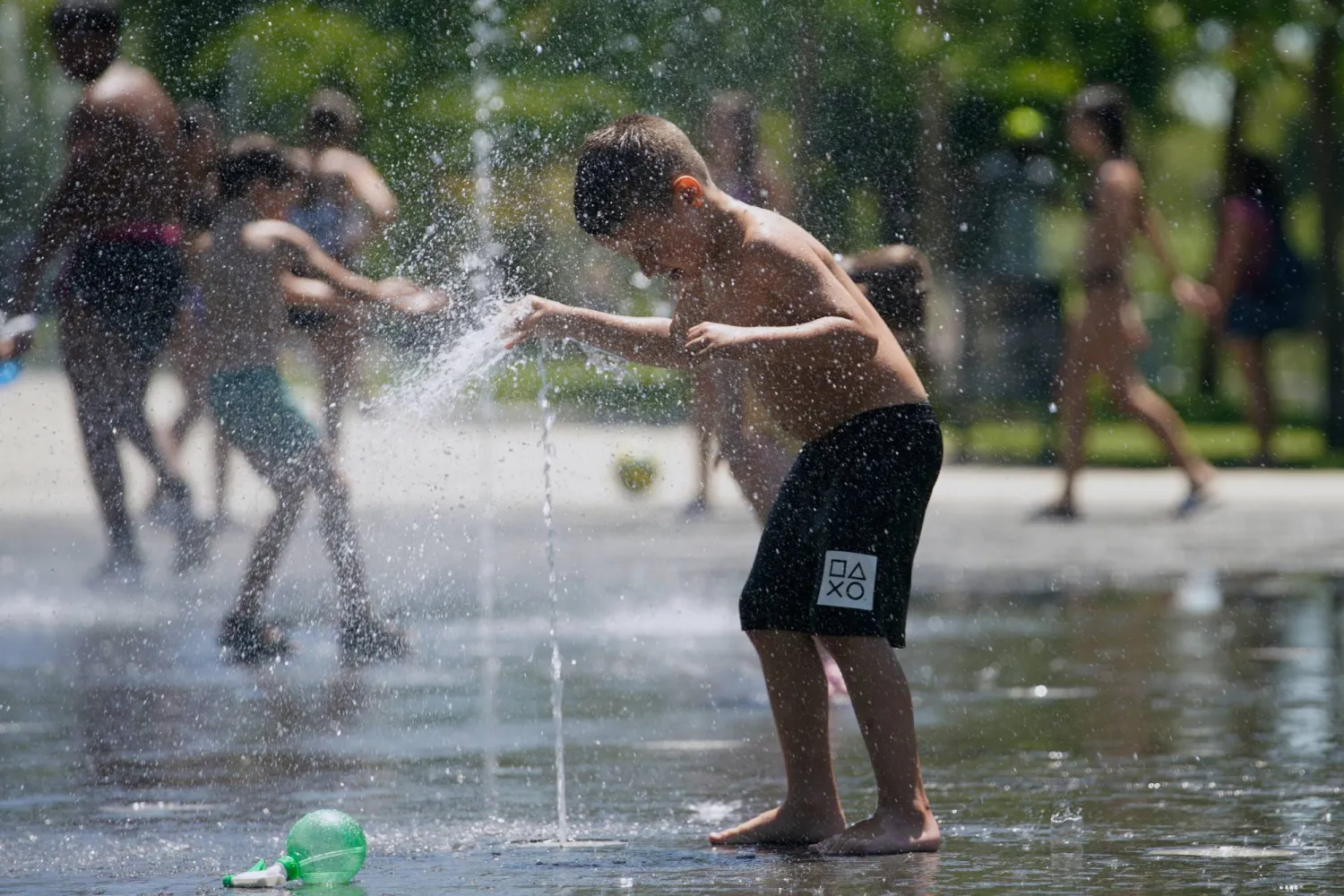 Children cool off at an urban beach of Madrid Rio park in Madrid, Spain, Thursday, July 2, 2026. (AP Photo/Andrea Comas)
