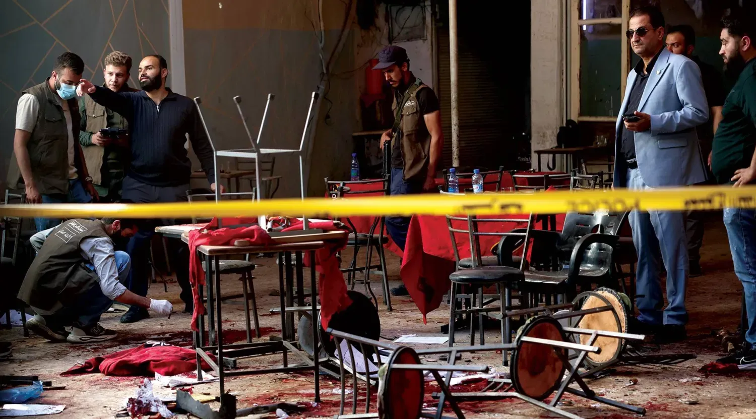 Suriye güvenlik güçleri dün Şam'daki adliye kompleksi yakınlarındaki bir kafede meydana gelen bombalı saldırının olay yerini inceliyor (AP)