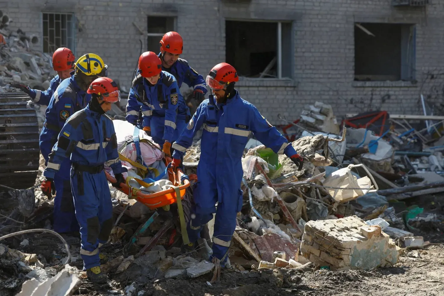 Kurtarma ekipleri, Kiev'de Rus hava saldırılarının ardından bir apartman binasının enkazı altında bulunan bir cesedi taşıyor (Reuters)