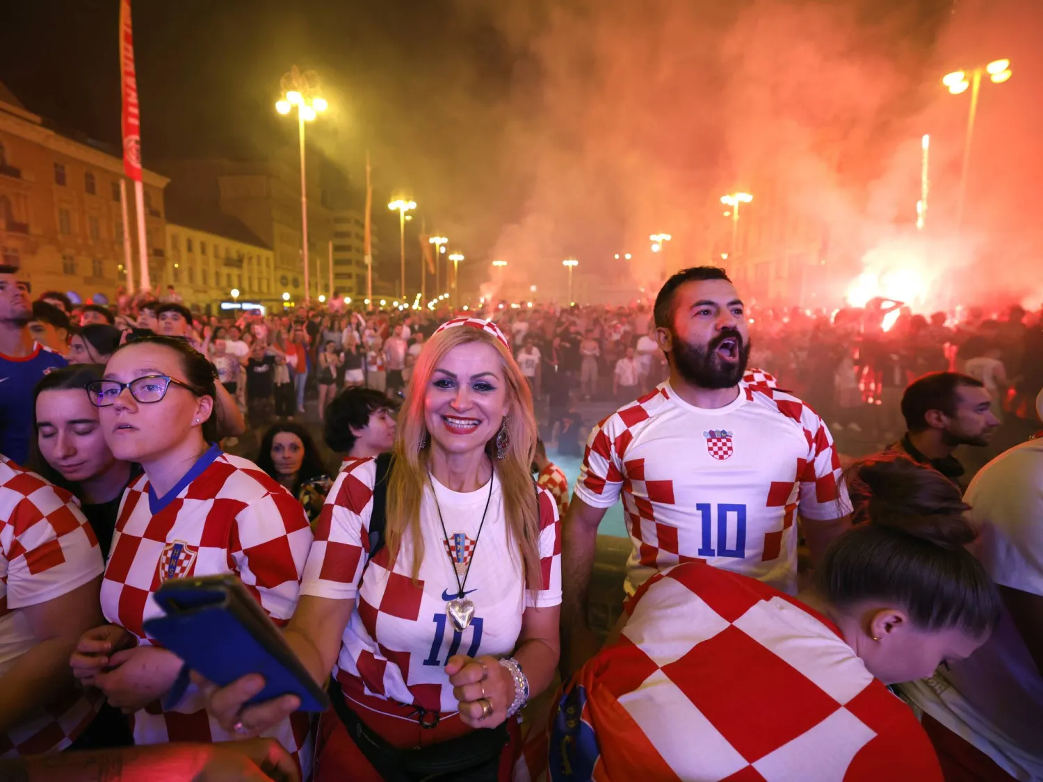 مشجعو كرة قدم كرواتيون يتفاعلون أثناء مشاهدة بث مباشر لمباراة البرتغال وكرواتيا في زغرب (إ.ب.أ) 