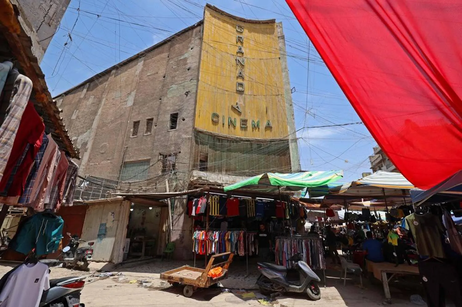 Street vendors gather outside the faded facade of the Granada Cinema, an early 1940s landmark, in the Bab al-Sharqi district of central Baghdad on May 26, 2026. (AFP)