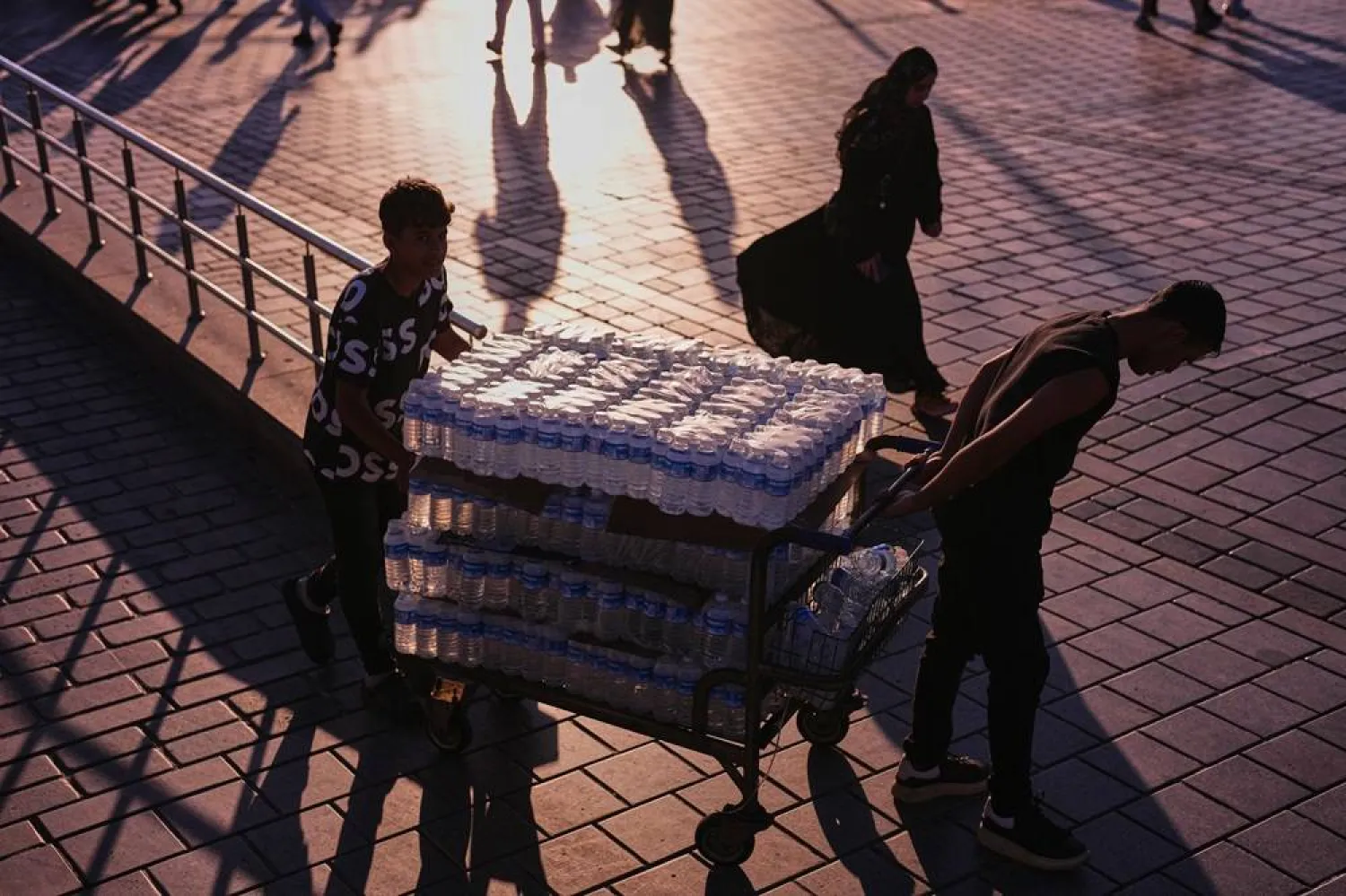 Workers deliver water bottles to a restaurant next to Galata bridge on a summer day in Istanbul, Türkiye, June 26, 2026. (AP) 