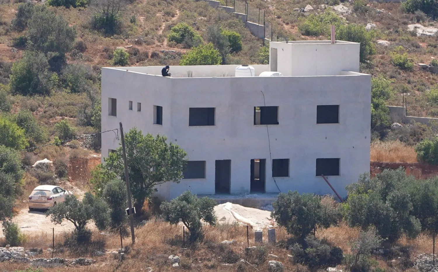  An Israeli settler sits on the roof of the Palestinian Salameh family house, which was taken over by Israeli settlers in the village of Jalud in the Israeli-occupied West Bank July 2, 2026. (Reuters)
