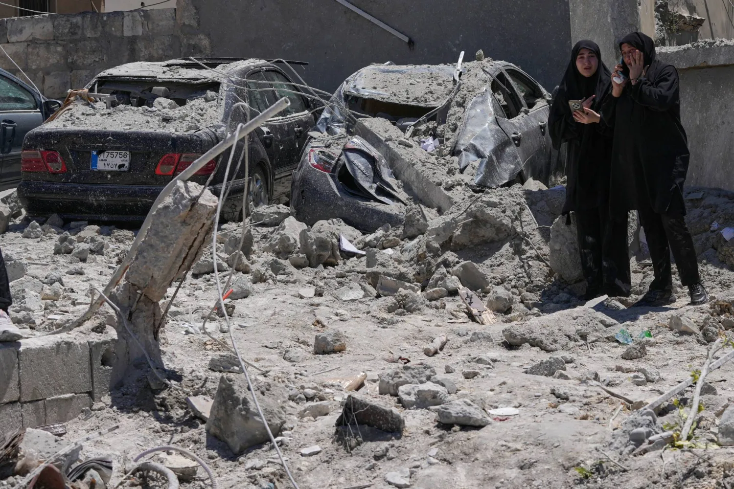 Relatives of missing victims weep, as they gather at the site of destroyed buildings that were hit in an Israeli airstrike in Qannarit village, southern Lebanon, Saturday, June 20, 2026. (AP Photo/Mohammed Zaatari)