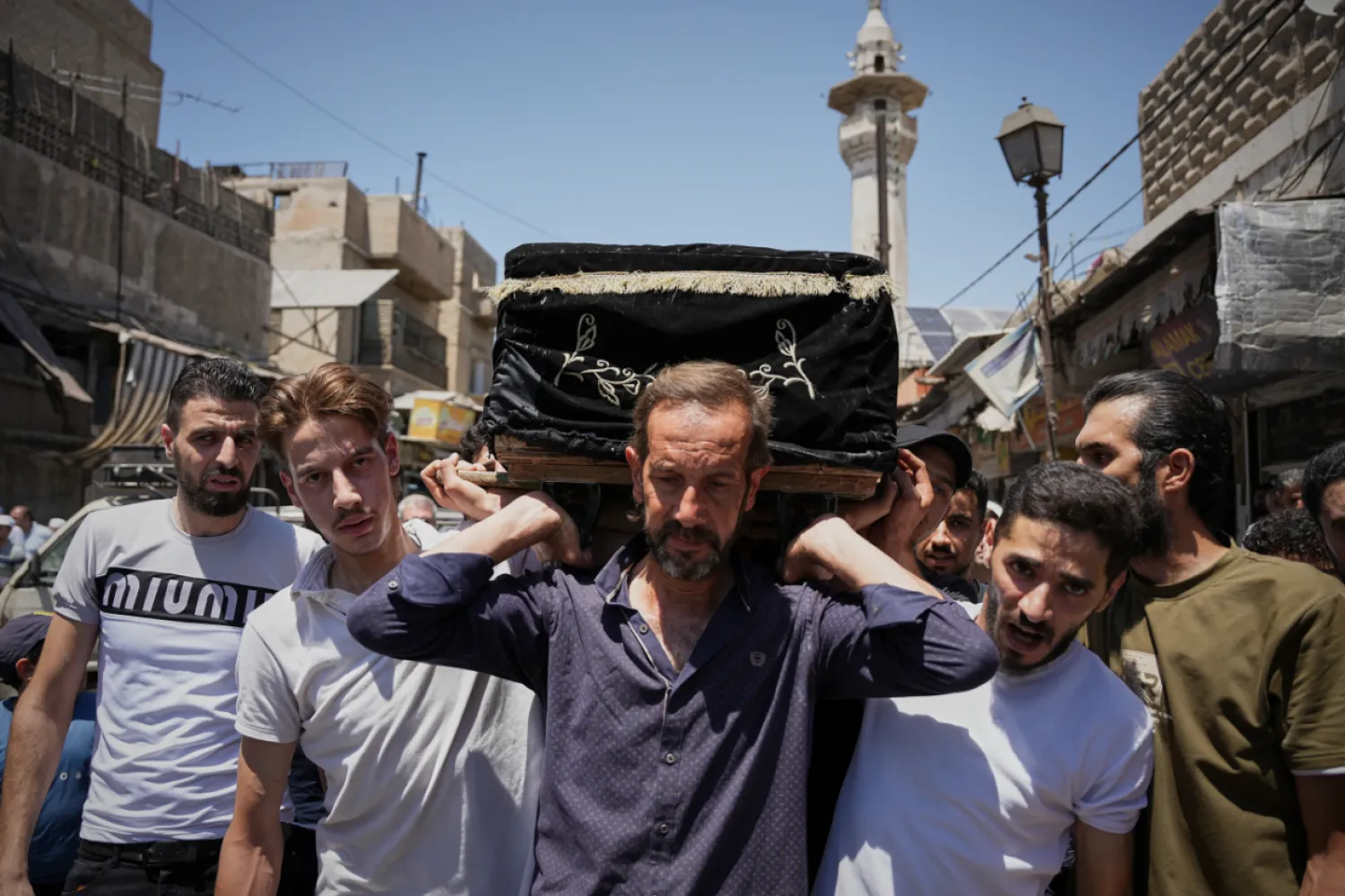 Mourners carry the coffin of Fathi Muhammad Saeed Qabbani, who was killed Tuesday when an explosive device detonated in a cafe near Damascus' main courthouse complex, during his funeral in the Al-Midan neighborhood of Damascus, Syria, Friday, July 3, 2026. (AP Photo/Omar Albam)